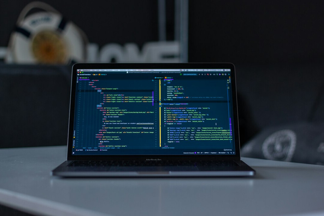 programmer coding on laptop